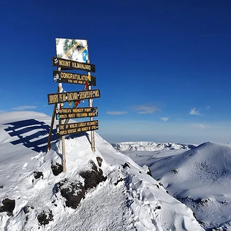 Uhuru Peak summit sign on Mount Kilimanjaro at dawn